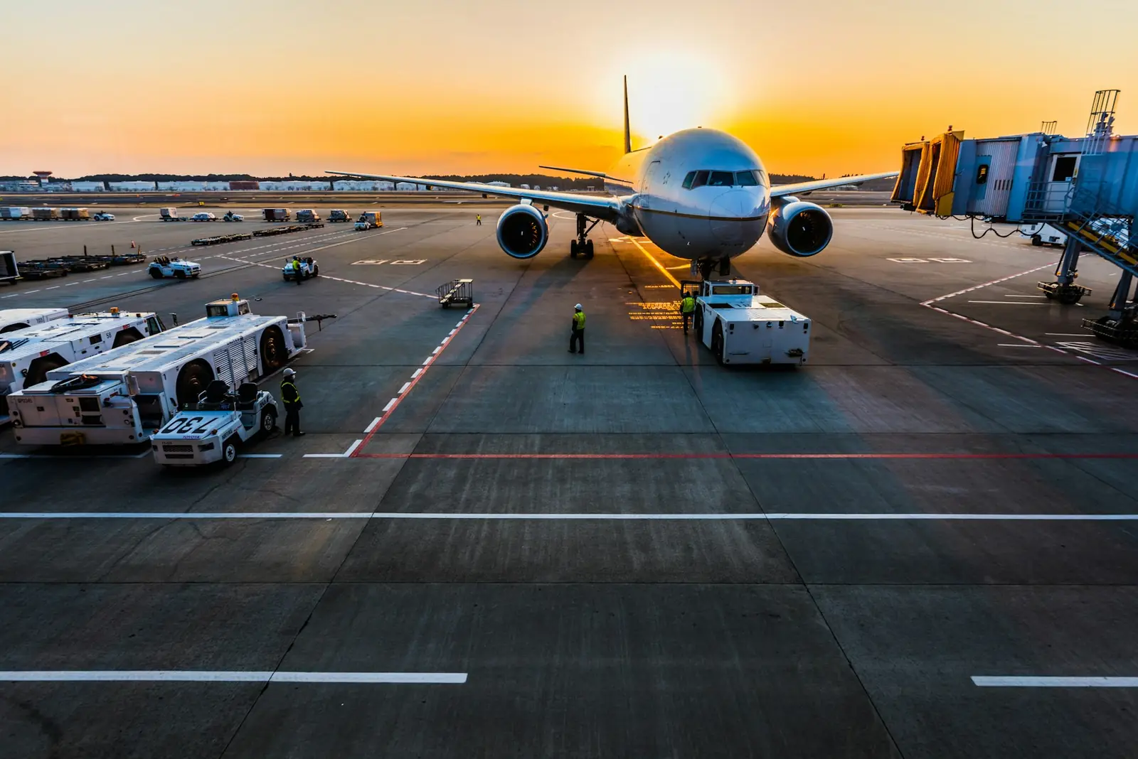Operación de carga aérea en plataforma de aeropuerto al atardecer