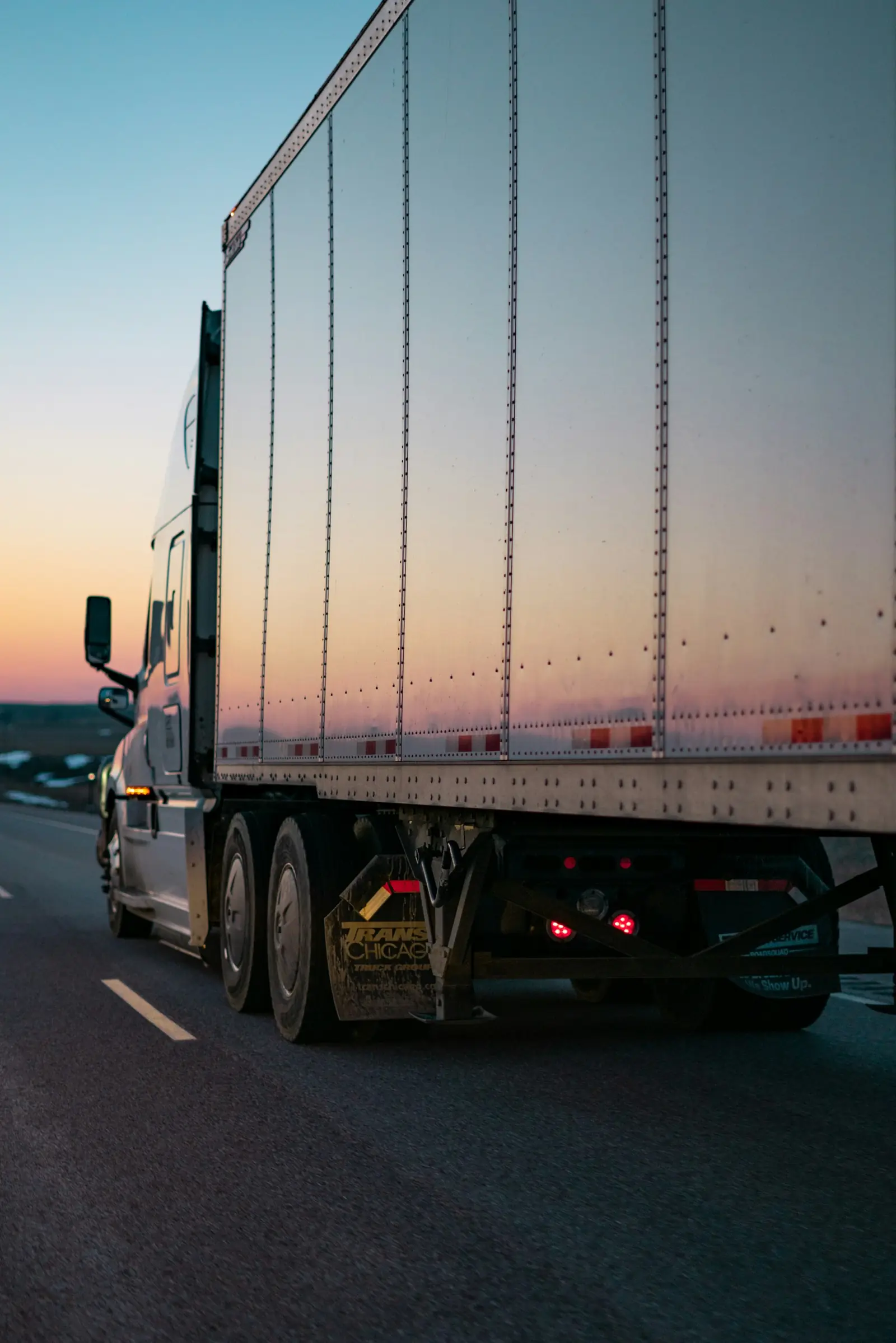 Caja seca de tractocamión en carretera al atardecer
